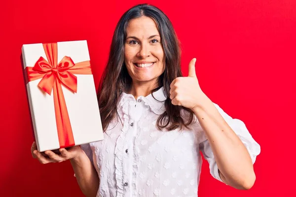 Jovem Bela Morena Segurando Presente Aniversário Sobre Fundo Vermelho Isolado — Fotografia de Stock