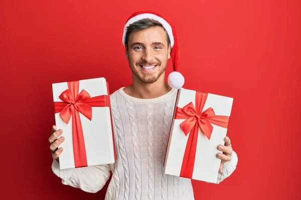 Hombre Caucásico Guapo Usando Sombrero Navidad Sosteniendo Regalos Sonriendo Con —  Fotos de Stock