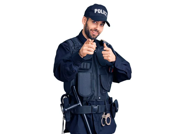 幸せと面白い顔でカメラに警察の制服を指差す指を身に着けて髭を生やした若いハンサムな男 良いエネルギーと振動は — ストック写真