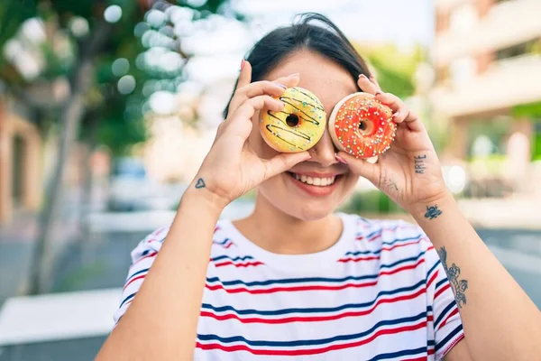 소녀는 행복하게 웃으며 도넛을 도시를 — 스톡 사진