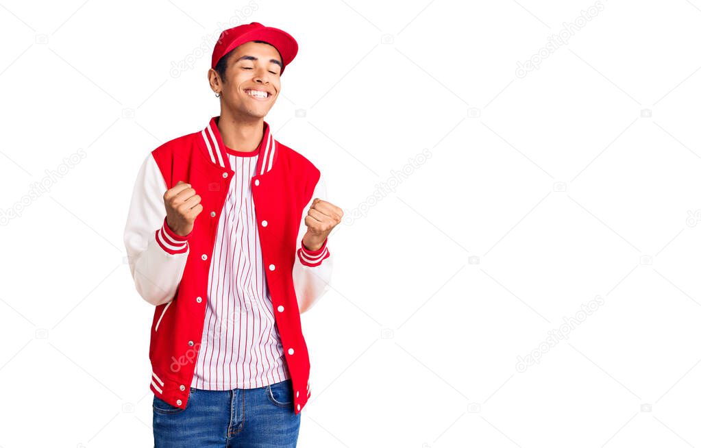 Young african amercian man wearing baseball uniform excited for success with arms raised and eyes closed celebrating victory smiling. winner concept. 