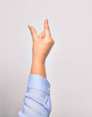 Beyaz arka planda yakalama işareti yapan beyaz bir kadın.