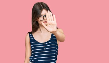 Gayri resmi giyinen ve gözlüklü güzel beyaz kız avucunun içi gibi şarkı söylemeyi kesiyor. Yüzünde olumsuz ve ciddi bir jest olan uyarı ifadesi. 