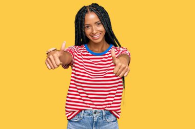 Güzel İspanyol kadın gündelik giysiler giyip olumlu jestler yapıyor. Elleriyle gülümsüyor ve başarı için seviniyor. kazanan jest. 