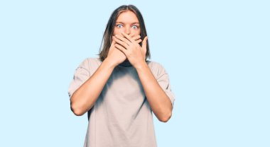 Uzun saçlı, sıradan kıyafetler giyen yakışıklı beyaz adam ağzını yanlışlıkla ellerle kapatmış. gizli kavram. 