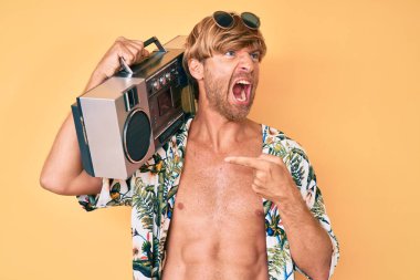 Yaz tarzı giyinmiş genç bir adam elinde teyp ile öfkeli ve öfkeli çığlıklar atıyor. Öfkeyle bağırıyor. öfke ve agresif konsept. 