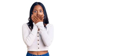 Gündelik kıyafetler giyen genç Hintli kız yanlışlıkla elleri ile ağzını kapatırken şok oldu. gizli kavram. 