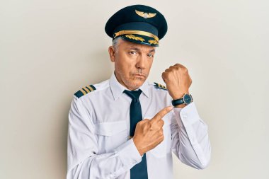 Yakışıklı, orta yaşlı, uçak pilotu üniforması giyen olgun bir adam. Aceleyle saati, sabırsızlığı ve rahat bir ifadeyle kameraya bakıyor. 