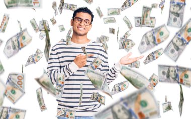 İspanyol asıllı yakışıklı genç adam, gündelik kıyafetler ve gözlük takıyor kameraya hayret ediyor ve gülümsüyor..