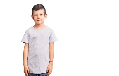 Yüzünde ciddi bir ifade olan sıradan kıyafetler giyen sevimli sarışın çocuk. Basit ve doğal bir şekilde kameraya bakıyorsun.. 