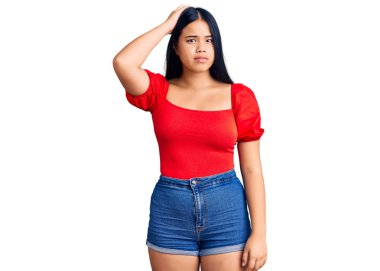 Gündelik kıyafetler giyen güzel Asyalı genç bir kız soru sorup kafasını karıştırıyor. Şüpheyle kararsız, kafa kafaya düşünerek. Düşünceli kavram. 