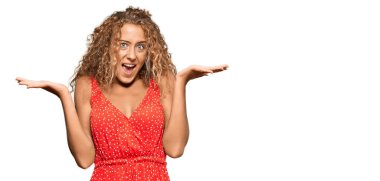 Yazlık elbise giyen güzel beyaz kız zaferi mutlu bir gülümsemeyle ve kazanan yüz ifadesiyle kutluyor. 