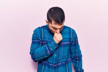 Rahat gömlekler giyen genç yakışıklı adam kendini iyi hissetmiyor ve soğuk algınlığı veya bronşitin belirtisi olarak öksürüyor. sağlık hizmeti kavramı. 