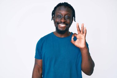 Saçları örgülü, gülümseyerek gülümseyen, el ve parmaklarıyla 