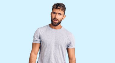 Şok olmuş gibi giyinen genç İspanyol adam şüpheci ve alaycı görünüyor, ağzı açık kalınca şaşırıyor. 