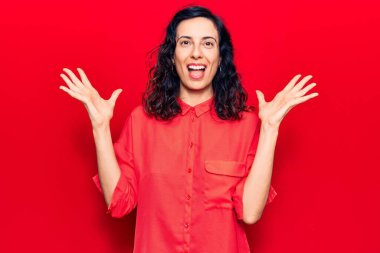 Genç ve güzel İspanyol kadın gündelik kıyafetler giyip zaferi mutlu bir gülümsemeyle ve kazanan yüz ifadesiyle kutluyor. 