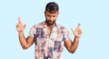 Yaz kıyafetleri giyen genç İspanyol adam umut ve gözleriyle gülümseyerek el sallıyor. Şans ve batıl inançlar. 