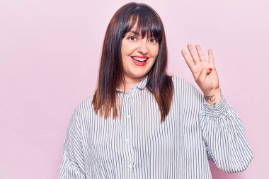 Genç ve cüsseli bir kadın dört numarayı gösterip gösterirken kendinden emin ve mutlu gülümsüyor.. 