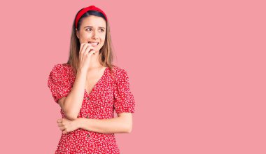 Elbise ve diyabet giyen genç ve güzel bir kız gergin ve elleri ağızdan tırnak yerken gergin görünüyor. anksiyete. 