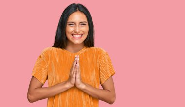 Genç, esmer, Arap bir kadın. Günlük kıyafetler giyiyor. Elleriyle dua ediyor, af diliyor.. 