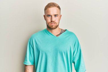 Sıradan kıyafetler giyen, komik yüzlü, yanak şişiren genç beyaz bir adam. Havayla şişmiş ağız, çılgın bir ifade.. 