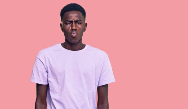 Genç Afro-Amerikan adam günlük kıyafetler giyip dudaklarıyla balık suratı yapıyor, çılgınca ve komik bir jest. Komik ifade. 