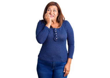 Orta yaşlı, güzel bir kadın. Günlük kıyafetler ve gözlük takıyor. Stresli ve gergin görünüyor..