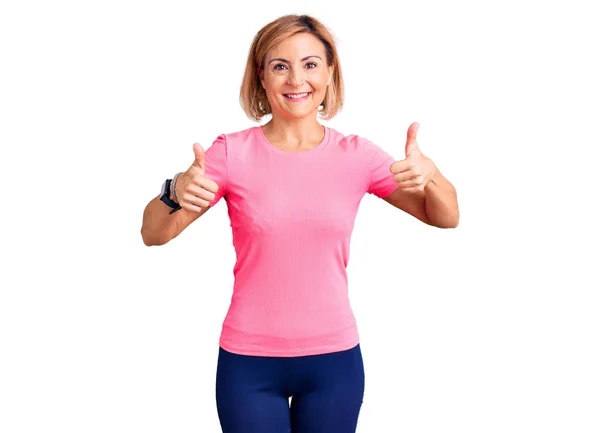 Young Blonde Woman Wearing Sportswear Success Sign Doing Positive Gesture — Stock Photo, Image