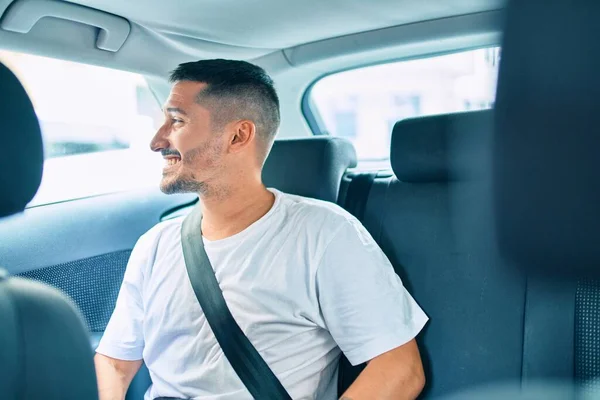 若いヒスパニック系の男笑顔幸せな車の上に座っている — ストック写真