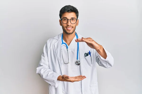 Młody Przystojny Mężczyzna Noszący Mundur Lekarza Stetoskop Gestykulujący Rękami Pokazującymi — Zdjęcie stockowe