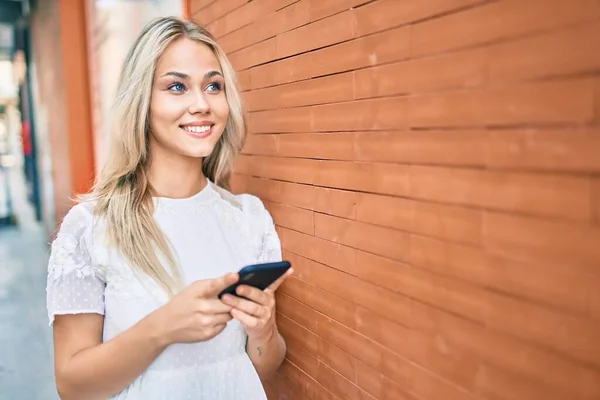 Junge Kaukasierin Lächelt Glücklich Mit Smartphone Die Wand Gelehnt — Stockfoto