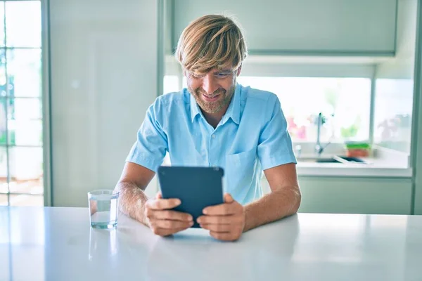 Joven Irlandés Sonriendo Feliz Usando Touchpad Sentado Mesa Casa — Foto de Stock