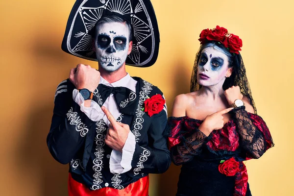 Casal vestindo fantasia de dia dos mortos sobre vermelho sorrindo fazendo  moldura com mãos e dedos com cara de feliz. conceito de criatividade e  fotografia.