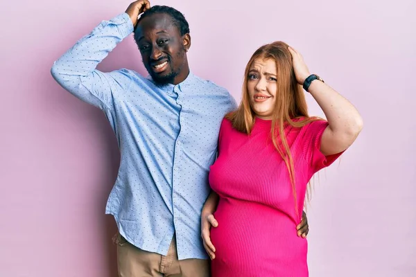 年轻的跨种族夫妇在等着孩子 触碰怀孕的肚子会让人困惑 并对问题感到疑惑 拿不定主意 手拿着头思考 沉思的概念 — 图库照片