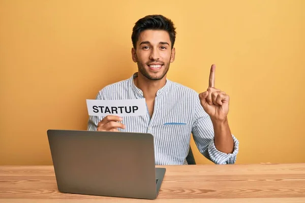 Jovem Homem Bonito Segurando Mensagem Inicialização Como Desenvolvimento Marketing Sorrindo — Fotografia de Stock