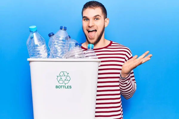 若いですハンサムな男リサイクルプラスチックボトル幸せな笑顔と受賞式で達成を祝う手を上げ — ストック写真