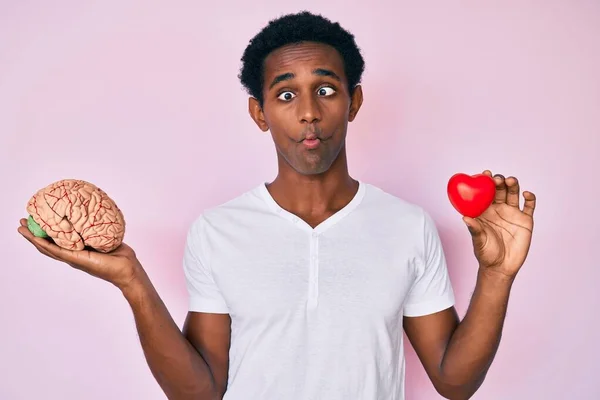 Hombre Africano Guapo Sosteniendo Cerebro Corazón Haciendo Cara Pez Con — Foto de Stock