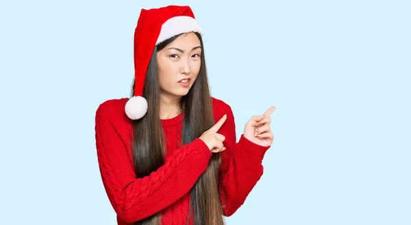 Jovem Chinesa Vestindo Chapéu Natal Apontando Para Lado Preocupado Nervoso — Fotografia de Stock