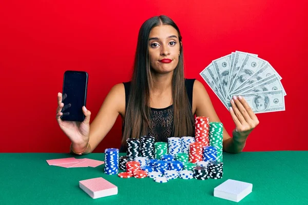 Νεαρή Ισπανίδα Που Παίζει Πόκερ Κρατώντας Smartphone Και Δολάρια Χαλαρή — Φωτογραφία Αρχείου
