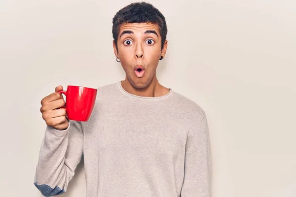 Young African Amercian Man Holding Coffee Scared Amazed Open Mouth — Stock Photo, Image