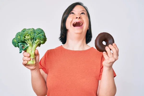 Mulher Morena Com Síndrome Segurando Brócolis Donut Chocolate Irritado Louco — Fotografia de Stock