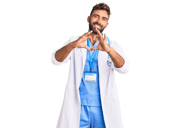 穿着医生制服和听诊器的年轻人面带微笑 爱上用手做心形符号 浪漫的概念 — 图库照片