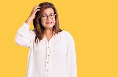 Gözlük takan orta yaşlı bir kadın kolları çapraz depresyondan bunalmış ve stresli görünüyor..