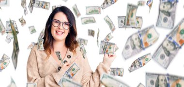 Güzel, genç, esmer bir kadın. Günlük kıyafetler ve gözlük takıyor. Gülümsüyor ve kameraya bakıyor..