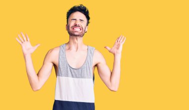 Gündelik kıyafetler giyen genç İspanyol adam başarı için deli ve çılgınlığı kutluyor kollarını kaldırmış ve gözlerini kapatmış heyecanla bağırıyor. Kazanan konsept 