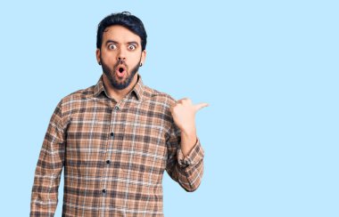 Gündelik giysiler giyen genç İspanyol adam elleri yana doğru işaret ederek şaşırdı, ağzı açık hayret içinde kaldı.. 