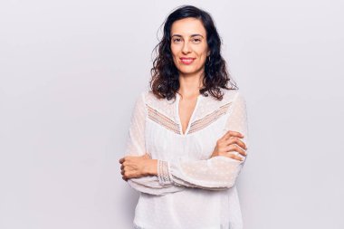 Gündelik kıyafetler giyen, kollarını kavuşturup kameraya gülümseyen genç, güzel İspanyol kadın. pozitif kişi. 