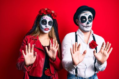 Ölü kostümün giyildiği gün kırmızı ellerle hareket eden çift avuç içleri korkuyla ve iğrenç bir ifadeyle reddedip inkar ediyor. Dur ve yasakla. 