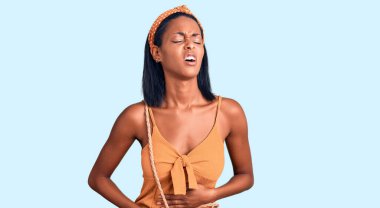 Genç Afro-Amerikalı kadın, mide bulantısı ve acı verici bir hastalık yüzünden el üstünde yaz kıyafeti giyiyor. Ağrı kavramı. 