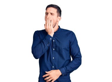 Gündelik tişört giyen genç yakışıklı adam ağzıyla esnemekten sıkıldı. Huzursuz ve uykulu.. 